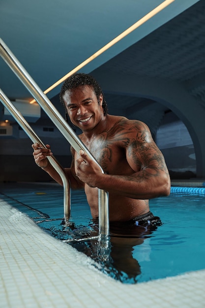 Retrato de moda de un hombre sexy muy musculoso en ropa interior en la piscina.