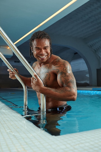 Retrato de moda de un hombre sexy muy musculoso en ropa interior en la piscina