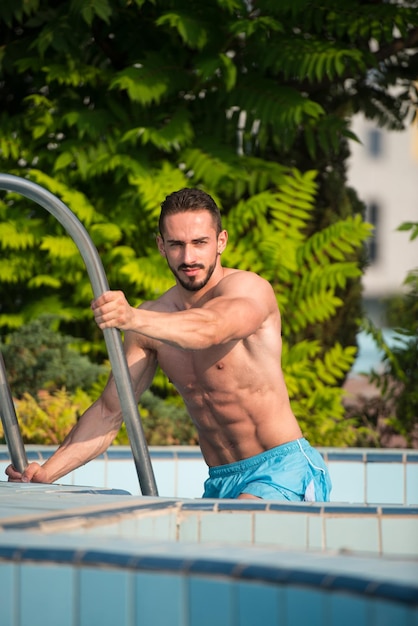 Retrato de moda de un hombre sexy muy musculoso en ropa interior en la piscina