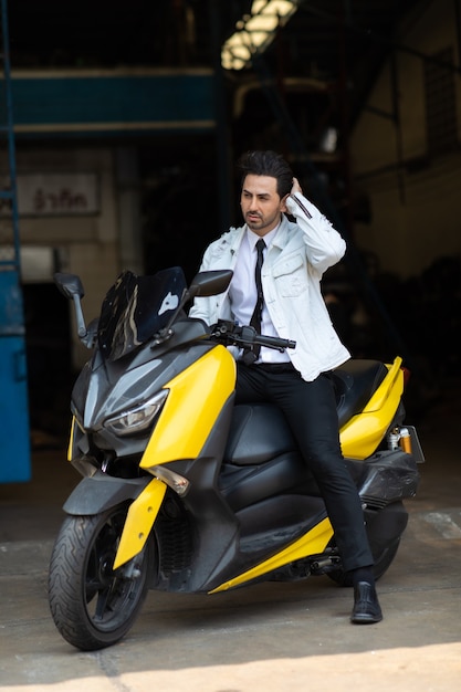 Foto retrato de moda joven guapo posando en moto