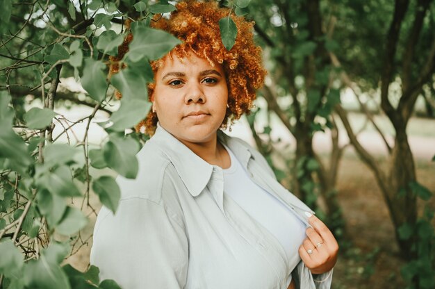 Retrato de moda de joven mujer afroamericana de talla grande naturalmente hermosa en traje de pantalón ligero