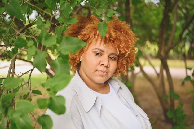 Retrato de moda de joven mujer afroamericana de talla grande naturalmente hermosa en traje de pantalón ligero