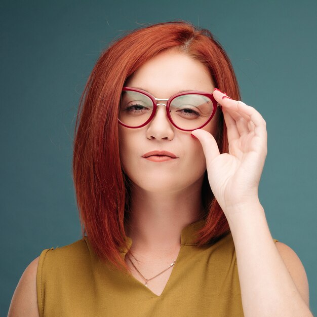 Retrato de moda de mujer de cabello rojo muy joven inconformista con gafas