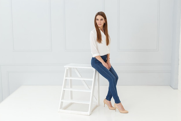 Retrato de moda de mujer en jeans en estudio de luz