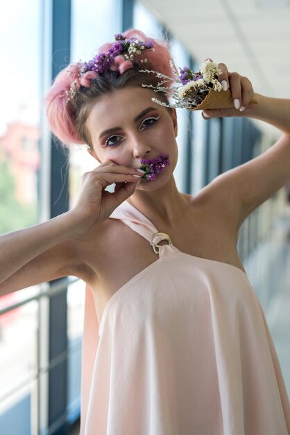 Retrato de moda de mujer joven con flores en la boca