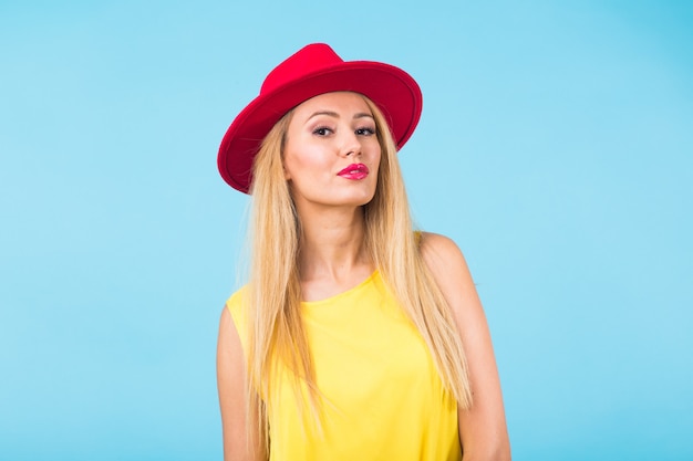 Retrato de moda de mujer joven en la pared azul.