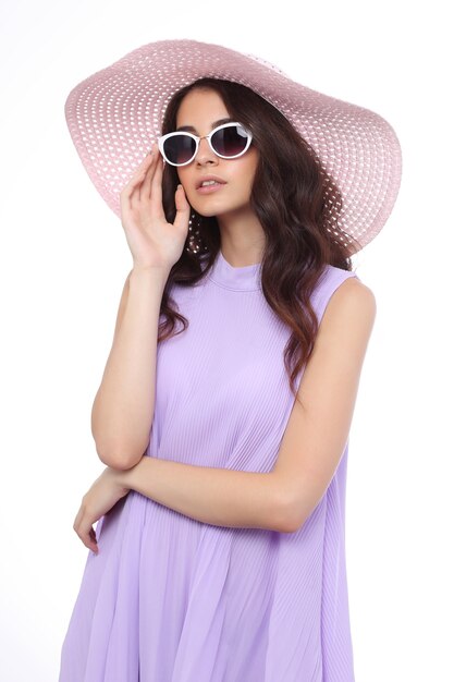 Retrato de moda de mujer joven con sombrero y gafas de sol.