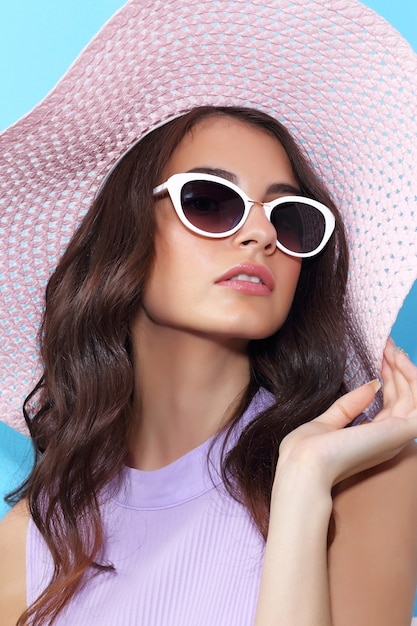 Retrato de moda de mujer joven con sombrero y gafas de sol.