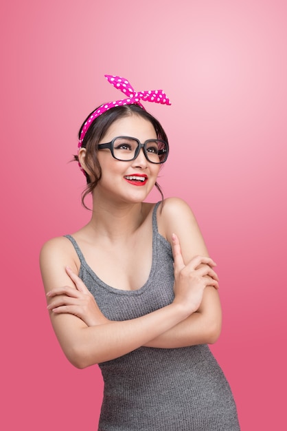 Retrato de moda de niña asiática con gafas de sol sobre fondo rosa.