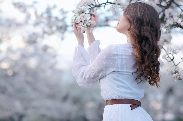 retrato de moda primaveral de una joven en un floreciente jardín de cerezos, ternura de la mañana