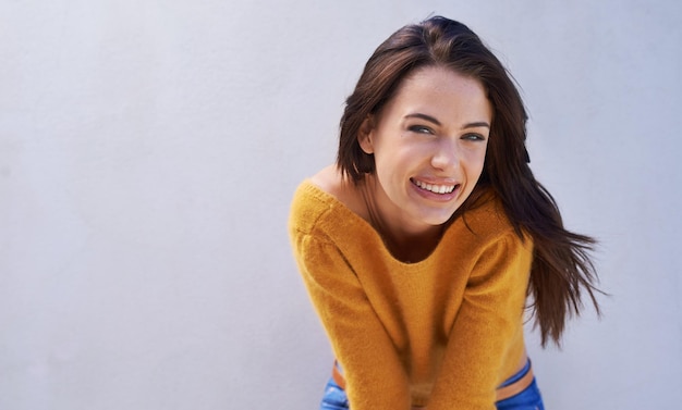 Foto retrato de moda y sonrisa de una mujer en una pared modelo o chica aislada en un espacio de maqueta de fondo púrpura belleza facial y persona feliz en ropa casual para estilo de moda en suéter fresco en italia