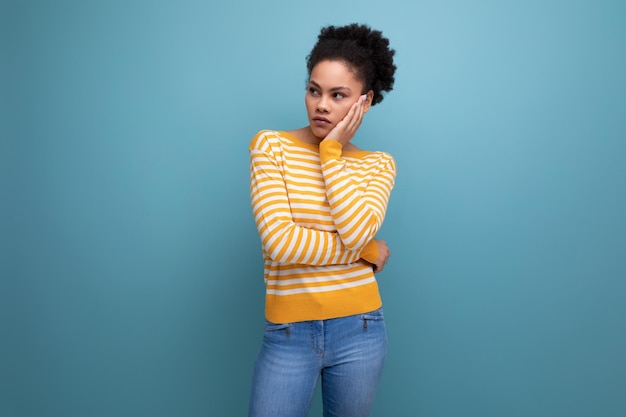 retrato, de, modelo, latina, joven, con, afro, rizos, en, estudio, plano de fondo