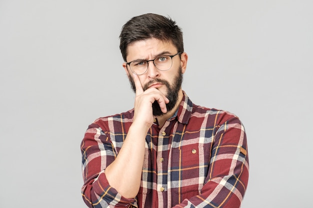 Retrato de modelo masculino inteligente enfocado con expresión pensativa y determinada