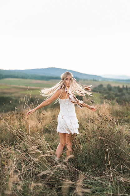 Retrato de modelo de moda de mujer al aire libre en el campo de verano, puesta de sol