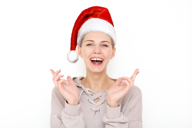 Retrato de modelo de mujer feliz con sombrero rojo de año nuevo levanta los dedos cruzados, hace que el deseo deseable espere buenas noticias.