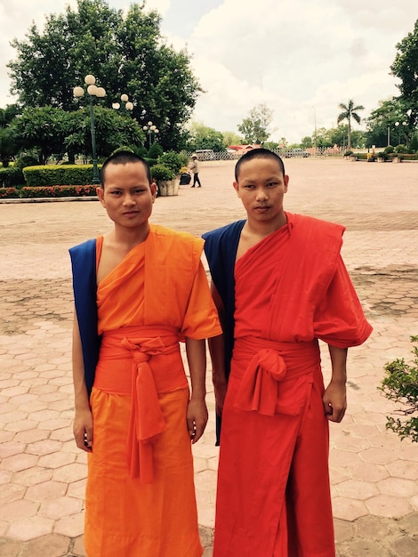 Foto retrato de monjes de pie en un sendero pavimentado