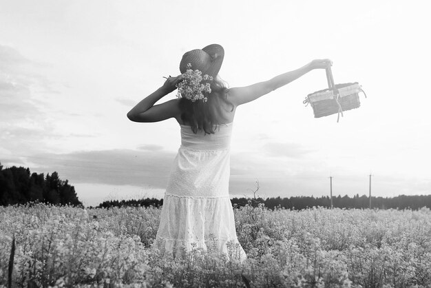 Retrato monocromático de jovem com um chapéu em um enorme campo de flores