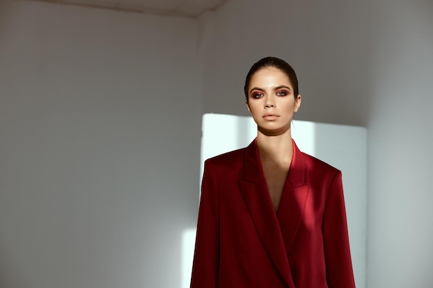 Retrato de una morena con maquillaje brillante y una chaqueta roja.