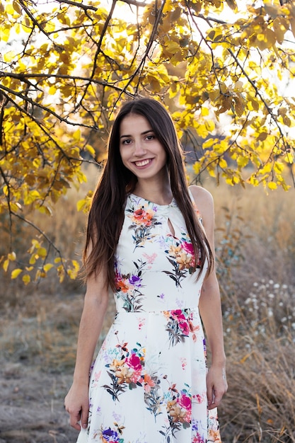Retrato de muchacha atractiva en vestido floral sonrisa con dientes