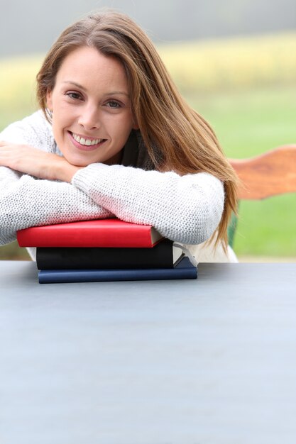 Retrato de muchacha hermosa que se inclina en los libros