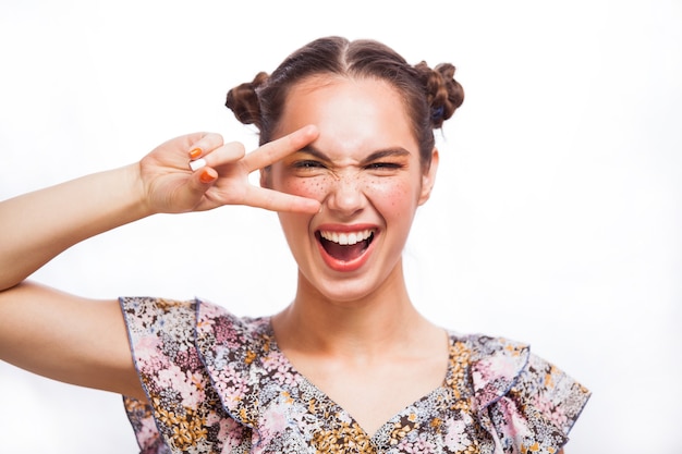 Retrato de la muchacha modelo de la belleza aislado en blanco. Hermosa chica adolescente alegre con pecas, peinado divertido y maquillaje amarillo y naranja. Maquillaje profesional.