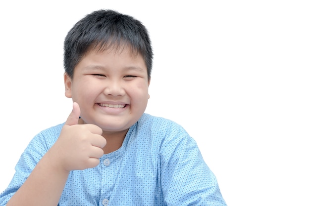 Retrato del muchacho gordo feliz asiático que muestra los pulgares encima del gesto, aislado sobre el fondo blanco