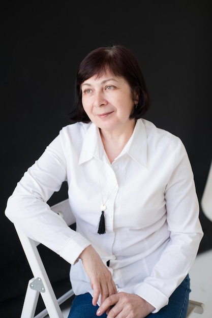 Retrato de una mujer de 50 años con un corte de pelo corto en una camisa blanca