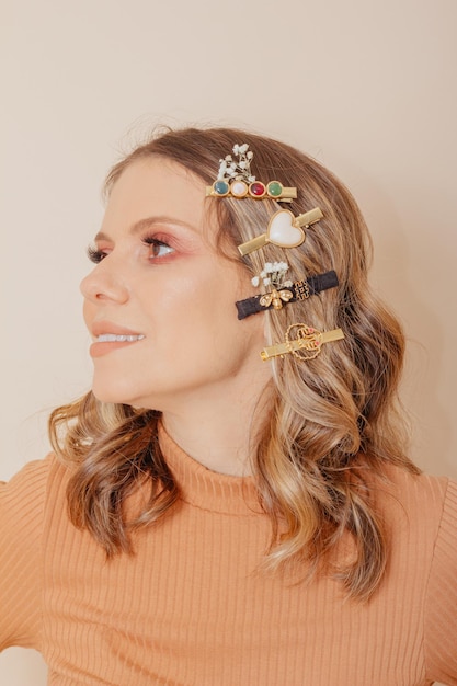 Foto retrato de mujer con accesorios para el cabello clipon sobre fondo crema concepto de otoño