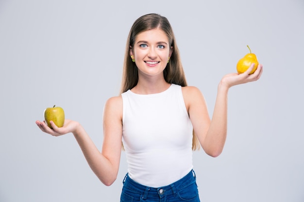 Retrato de una mujer adolescente feliz con manzana y pera aislado