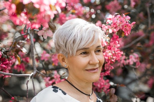 retrato de una mujer adulta hermosa en árboles florecientes