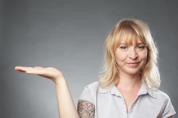 Retrato de una mujer adulta en uniforme gestando contra un fondo gris