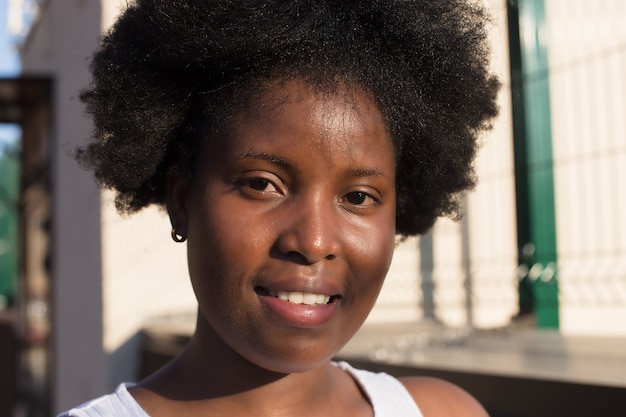 Retrato de una mujer afroamericana feliz en la calle en verano.