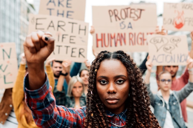 Retrato de una mujer afroamericana con puño cerrado en una huelga climática global