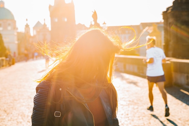 Retrato de mujer al amanecer con el pelo desordenado por el viento