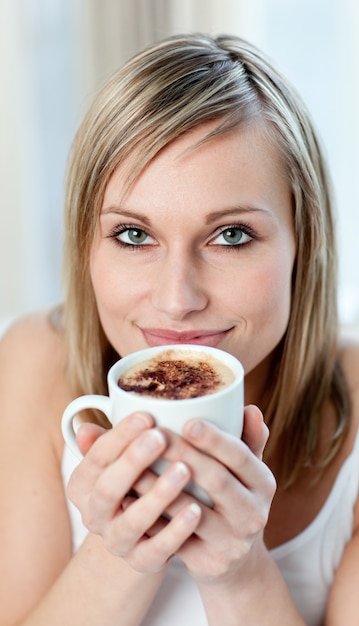 Retrato de una mujer alegre bebiendo un café