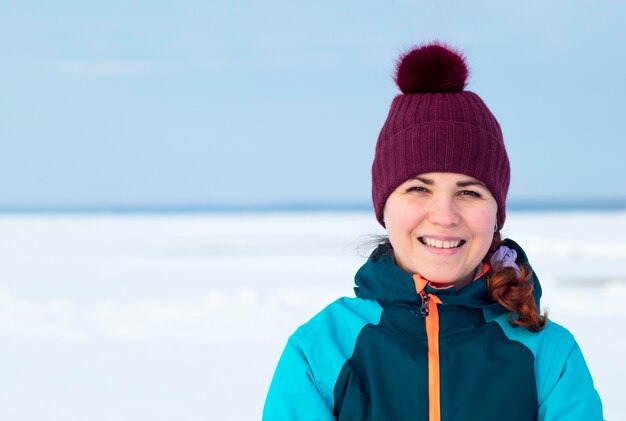 Retrato de una mujer alegre feliz de pie al aire libre en ropa de invierno abrigada