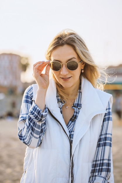 Retrato de mujer alegre con gafas de sol en la playa