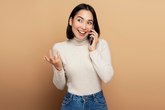 Retrato de mujer alegre hablando con un amigo por teléfono celular