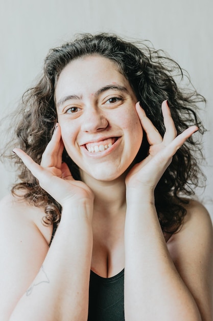 Retrato de una mujer alegre con las manos en la cara expresando felicidad