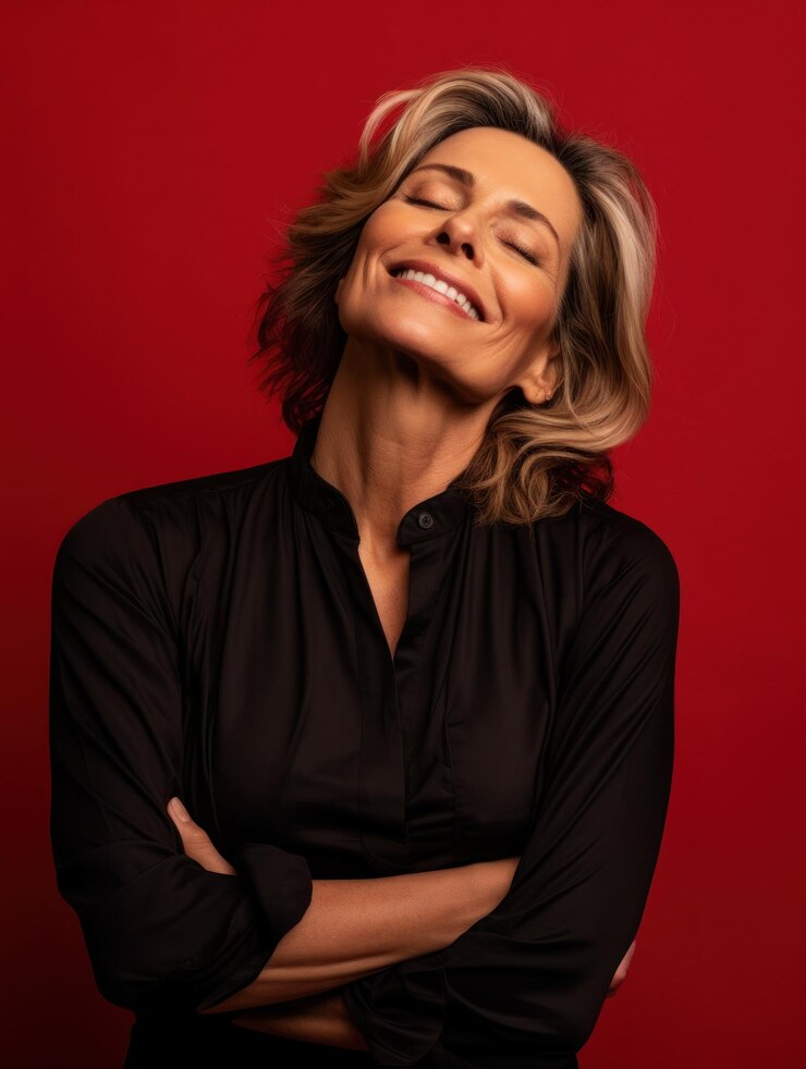 Retrato de una mujer alegre de mediana edad abrazándose a sí misma abrazándose con amor propio