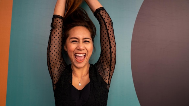 Retrato de una mujer alegre de pie contra la pared