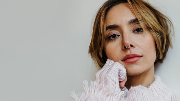 Retrato de una mujer alegre con un suéter rosa claro