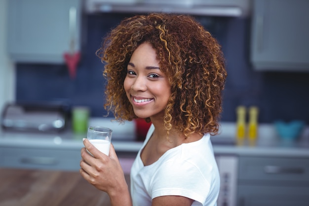 Retrato de mujer alegre con vaso de leche