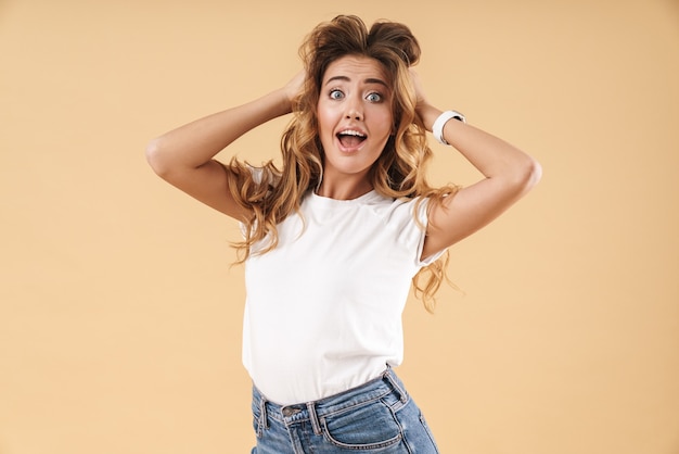 Retrato de mujer alegre vestida con ropa casual preguntándose y tocando su cabello aislado