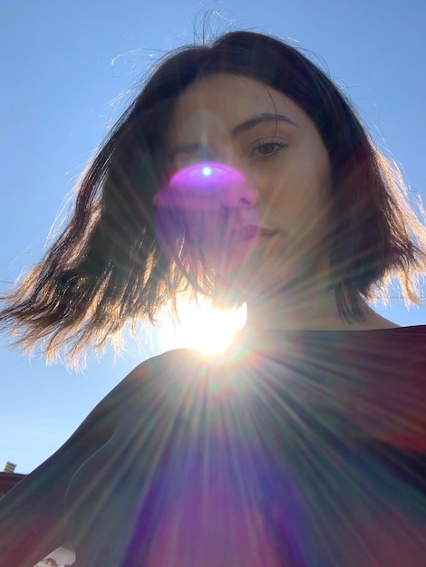 Foto retrato de mujer en bajo ángulo contra el cielo durante un día soleado