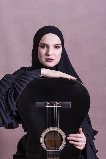 Foto retrato de mujer árabe con guitara