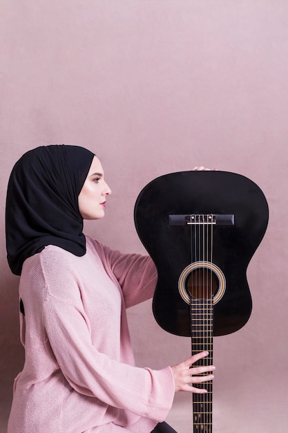 Foto retrato de mujer árabe con guitara