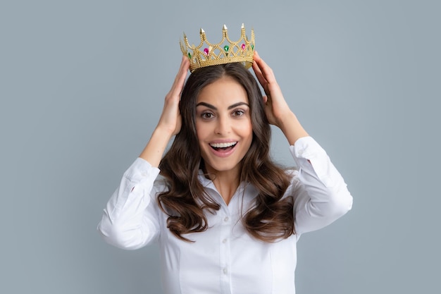 Retrato de mujer arrogante con corona de oro en la cabeza liderazgo y éxito Atractiva chica rica y arrogante con corona aislada sobre fondo gris