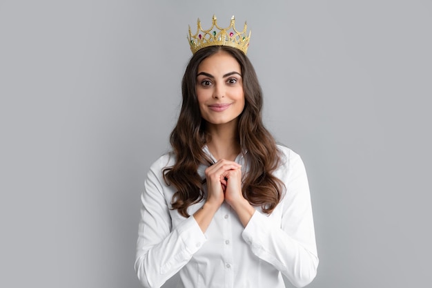 Retrato de mujer arrogante con corona de oro en la cabeza liderazgo y éxito Atractiva chica rica y arrogante con corona aislada sobre fondo gris