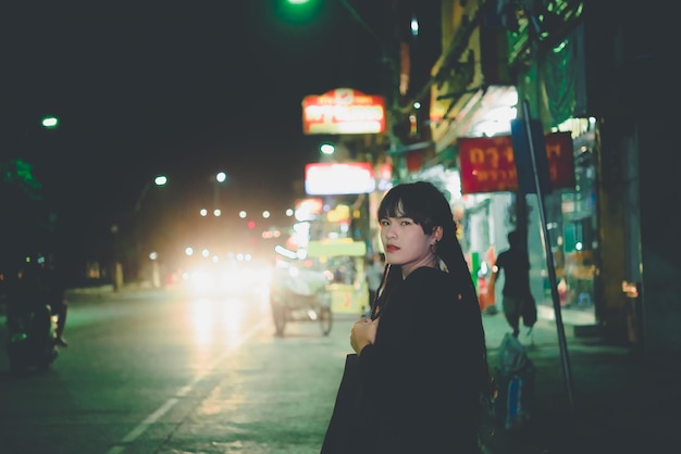 Retrato de mujer asiática cabello dreadlock escena nocturna en la ciudad La gente de Tailandia posan para tomar una foto sintiendo el concepto de mujer sola y triste